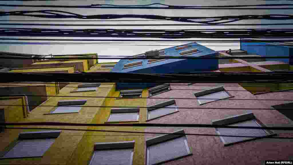 Kjo fotografi ta jep një përshtypje se si do të ishte të shikosh lart nëse ndodhësh pranë kësaj ndërtese në rrugën "Gustav Meyer" në lagjen "Dodona".