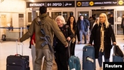 Un soldat israelian își întâmpină la aeroportul Ben Gurion rudele întoarse din Italia cu unul din primele zboruri după redeschiderea spațiului aerian.