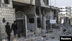 Free Syrian Army fighters inspect the damage after an air strike by government forces in Ghouta, east of Damascus, on November 17.