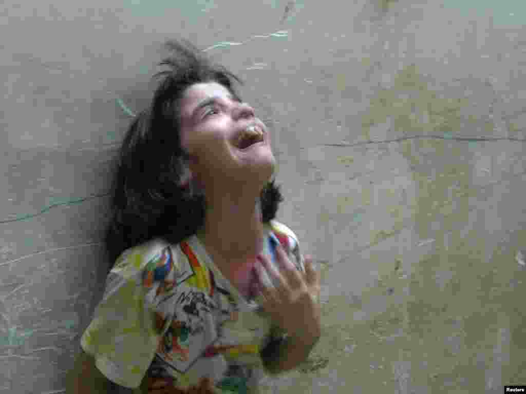 Mays, a young Iraqi Shi'ite girl, cries after a mortar shell which landed outside the family's home in a Najaf residential area injured her uncle August 18, 2004. The leader of a Shi'ite uprising in Iraq agreed on Wednesday to leave a holy shrine encircled by U.S. marines, hours after the interim government threatened to storm it and drive out his fighters. But even after the announcement, explosions and gun fire echoed through the streets as U.S. forces battled Sadr's Mehdi Army militiamen, whose two-week-old uprising poses the biggest challenge yet to Iraq's interim government. REUTERS/Ali Jasim 