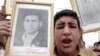 A protester in Baghdad carries a picture of a relative killed at Al-Dujayl