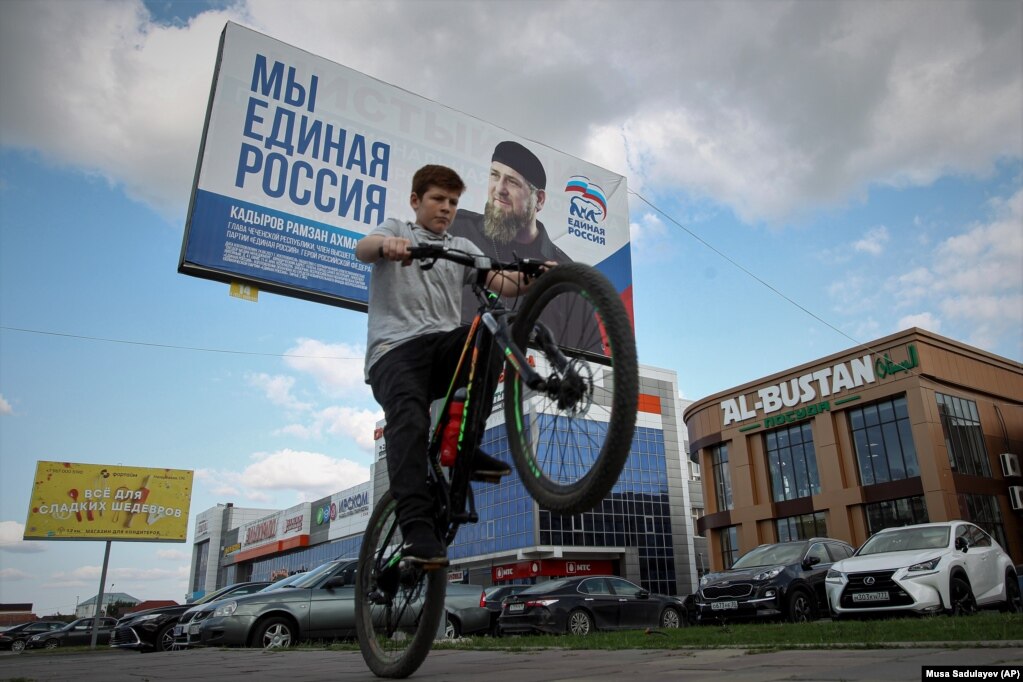 Një djalë kalon pranë një posteri të partisë Rusia e Bashkuar, ku shfaqet portreti i liderit çeçen, Ramzan Kadyrov.