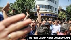 IRAN -- A group of protesters chant slogans at the main gate of old grand bazaar in Tehran, Iran, Monday, June 25, 2018. Protesters in the Iranian capital swarmed its historic Grand Bazaar on Monday, news agencies reported, and forced shopkeepers to close