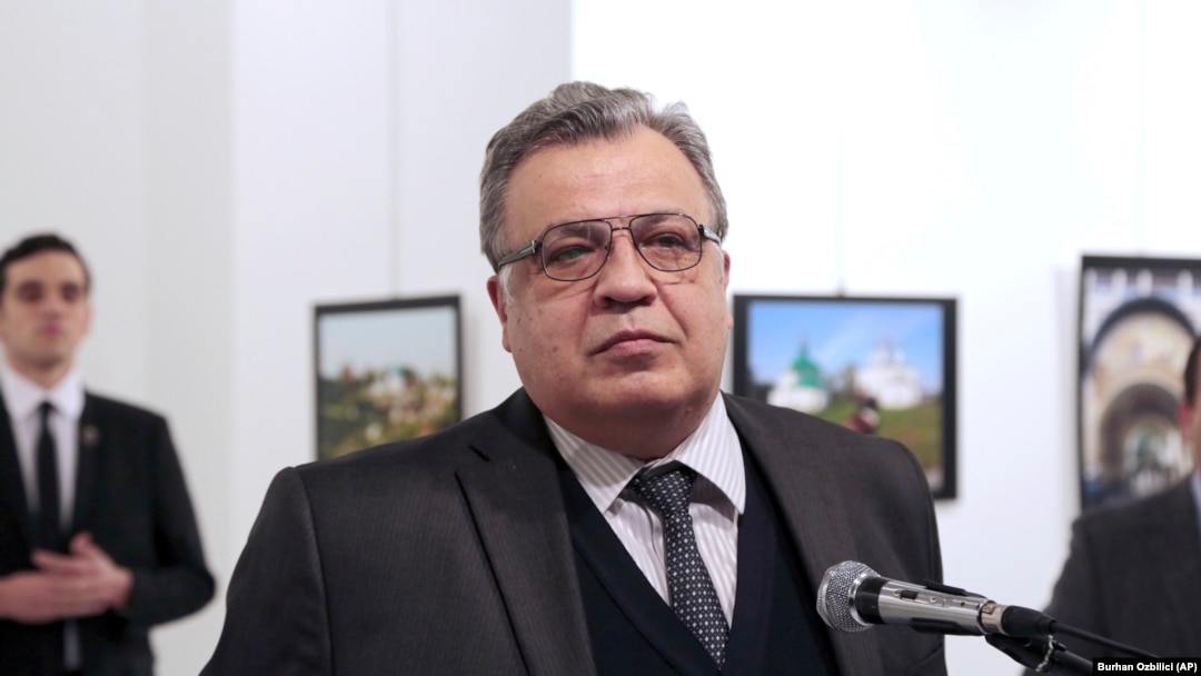 Andrei Karlov, the late Russian Ambassador to Turkey, at an exhibition in Ankara moments before he was shot dead by Mevlut Mert Altintas, who is visible in the background on the left. (file photo)