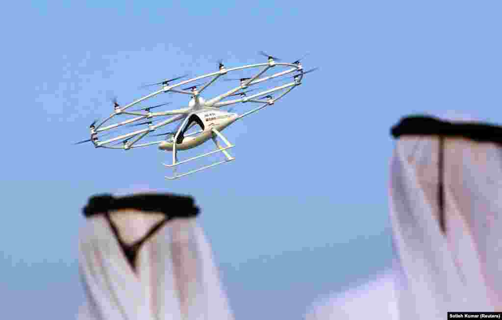 Men look at the flying taxi in Dubai, United Arab Emirates. (Reuters/Satish Kumar)