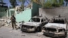 A member of the Afghan security forces stands guard next to damaged army vehicles after a Taliban attack in the city of Ghazni, August 15, 2018.