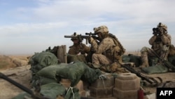 U.S. Marines take position on a rooftop northeast of Marjah in Helmand Province.