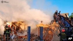 Zjarrfikësit duke punuar në një objekt të shkatërruar pas një sulmi raketor rus në rajonin e Kievit, 8 maj 2024.
