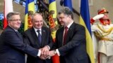 O strângere de mâini între liderii unor ţări prietene. Preşedintele Nicolae Timofti între preşedinţii Bronislaw Komorowski (stânga) şi Petro Poroşenko, Chişinău, 20 noiembrie 2014