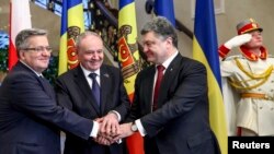 O strângere de mâini între liderii unor ţări prietene. Preşedintele Nicolae Timofti între preşedinţii Bronislaw Komorowski (stânga) şi Petro Poroşenko, Chişinău, 20 noiembrie 2014