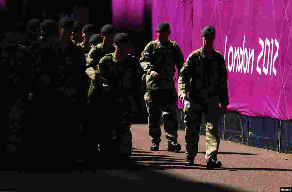 U.K. - Soldiers patrol past signage for the London 2012 Olympic Games near the beach volleyball courts at Horse Guards Parade in London, 24Jul2012