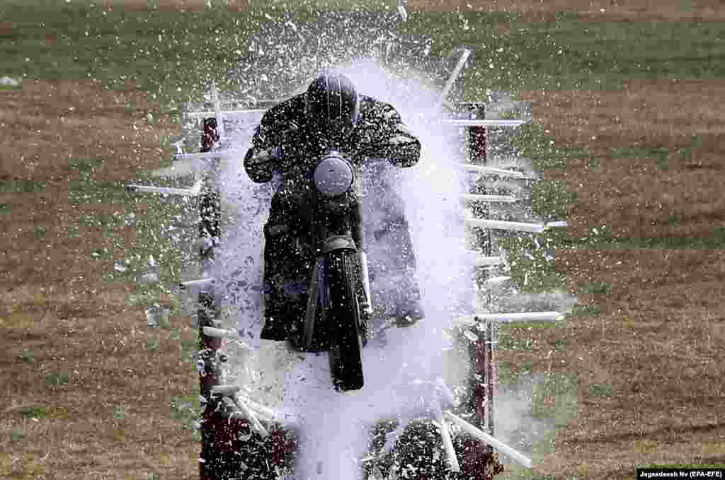 An Indian Army serviceman displays his motorbike skills during an event at a training college in Bangalore. (epa-EFE/Jagadeesh)