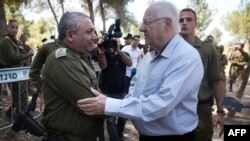 Israeli President Reuven Rivlin (R) is greeted by Israeli chief of Staff Gadi Eizenkot as he visits near the Israel-Gaza border area on August 23, 2016 (Photo by MENAHEM KAHANA / AFP)