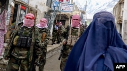 Talibanın təhlükəsizlik xidmətinin əməkdaşları və burka geyinmiş əfqan qadını