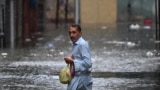A man wades through a flooded street during heavy monsoon rains in Rawalpindi in Pakistan. 