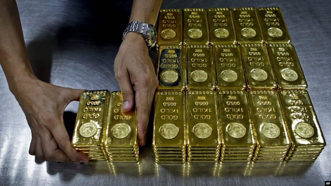 Texniki işçi Dubayda yerləşən "Emirates Gold" şirkətinə çatdırmaq üçün 1 kq qızıl külçəni qablaşdırır.