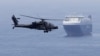 A US Army helicopter escorts a ship through the Strait of Hormuz. (file photo)