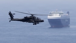 A US Army helicopter escorts a ship through the Strait of Hormuz. (file photo)