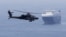 A US Army helicopter escorts a ship through the Strait of Hormuz. (file photo)