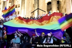 LGBT activists display a rainbow flag in front of the cross on July 6.