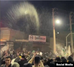 Protesters scatter rice on the streets of Abdanan last night.