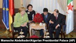Абдэль Азіз Бутэфліка (крайні справа) падчас сустрэчы з Ангелай Мэркель, 17 верасьня 2018