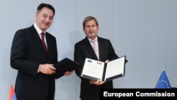 Belgium - EU Enlargement Commissioner Johannes Hahn (R) and Armenian Economy Minister Karen Chshmaritian sign a memorandum of understanding in Brussels, 3Nov2014.