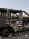 An Iranian woman looks at an ambulance burned in Israeli strikes on Tehran during the <a href="https://www.rferl.org/a/khamenei-leadership-iran-irgc-military-takeover/33456933.html" target="_self">1<strong>2-day conflict</strong></a> between the two countries. 