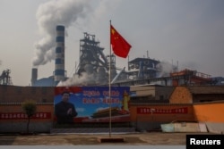 Плакат с изображением президента Китая Си Цзиньпина перед металлургическим заводом Xinyuan в Аньяне, провинция Хэнань, Китай, 19 февраля 2019 года.