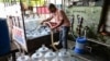 Manoj Karnani, a courier company owner fills drinking water into bottles at the railway station in Ahmedabad on June 3, 2026.