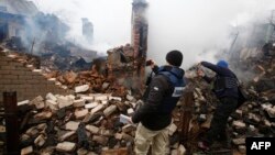 Anëtarët e misionit të OSBE-së në Ukrainë duke e fotografuar një shtëpi të shkatërruar në vendin Avdiivka