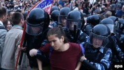 Russian police detain a protester at an unauthorized opposition rally in central Moscow on June 12.