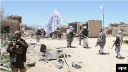 FILE: Suspected Taliban militants patrol after they reportedly took control of Ghazni's Waghaz district in May 2017. 