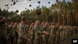 Soldați ucraineni sărbătoresc sfârșitul antrenamentului lor la o bază militară din apropierea Kievului, septembrie 2023. 