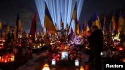 People mark the fourth anniversary of Russia's invasion of Ukraine, at the Lychakiv cemetery in Lviv