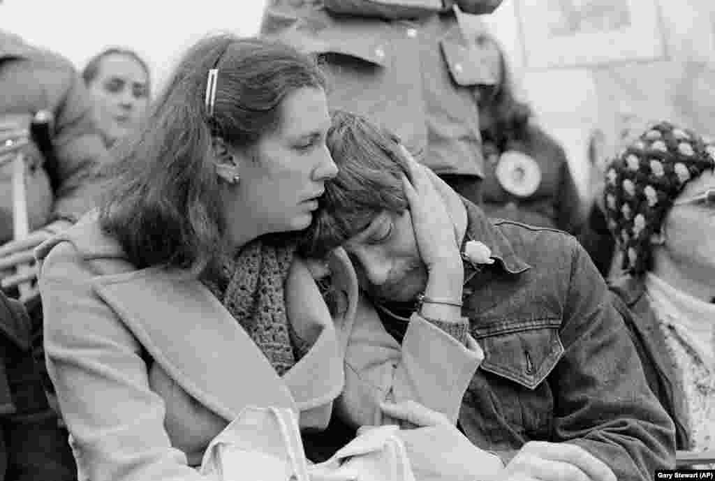Женщина утешает плачущего мужчину на траурной церемонии в Сиэтле, 14 декабря 1980 года