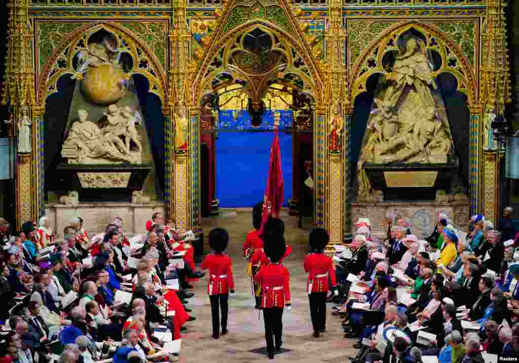 Soldații trec pe lângă oaspeții așezați în Westminster Abbey, Londra, înainte de încoronarea regelui Charles al III-lea și a reginei Camilla. Sâmbătă, 6 mai 2023. Ben Birchall/Pool via REUTERS