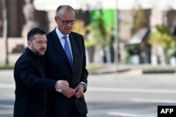 Президент України Володимир Зеленський і канцлер Німеччини Фрідріх Мерц біля стихійного меморіалу українським та іноземним воїнам на Майдані Незалежності в Києві, Україна, 4 жовтня 2026 року