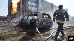 Ukrainian firefighters extinguish a blaze on September 1 after a Russian missile attack in Kharkiv.