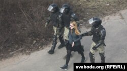 A woman is detained by riot police in Minsk on March 27.