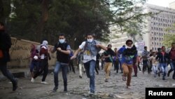 Демонстранти втікають від поліції в околиці площі Тахрір, 27 листопада 2012 року
