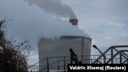 Disa këmbësorë duke ecur afër termocentralit Kosova B në Obiliq.
