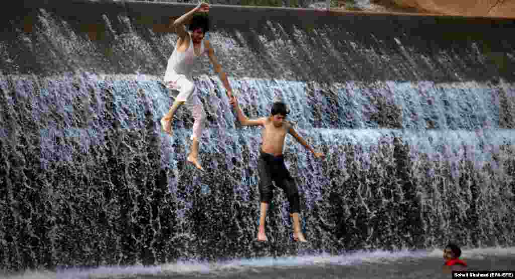 Pakistani boys cool off in the waters of the Simli Dam amid a heat wave in Islamabad.&nbsp;