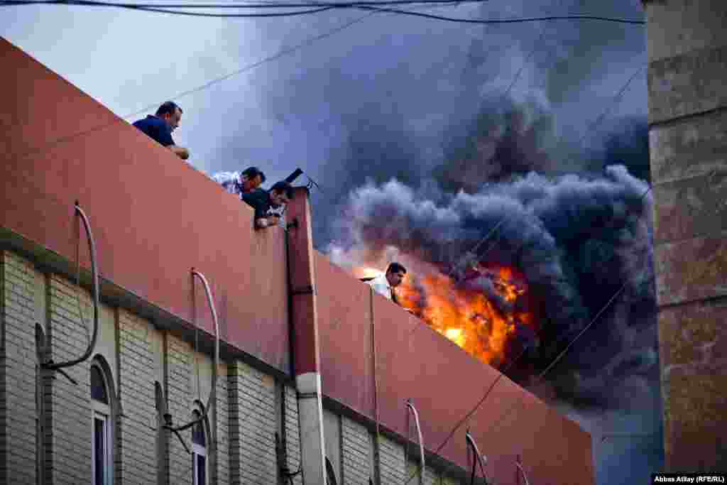 Ərbil bazarında yanğın. Yanğın zamanı binanın üst mərtəbəsində işləyən insanlar çıxılmaz vəziyyətdə yanğın söndürənləri gözləyirlər