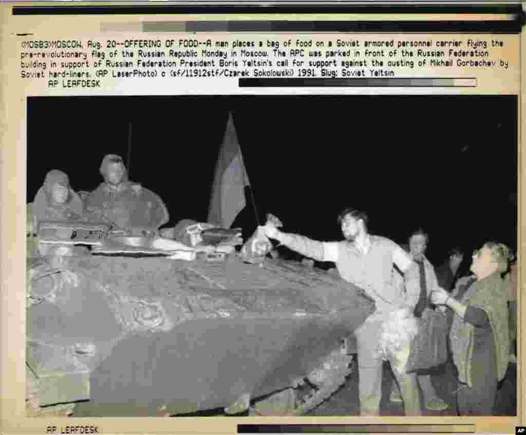 Demonstrators offer food to Soviet soldiers who broke away from their unit to support the anti-coup leaders.&nbsp;
