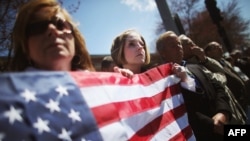 U.S. -- Jaime Caputo (C) holds an American flag outside the funeral for 29-year-old Krystle Campbell, who was one of three people killed in the Boston Marathon bombings, in Medford, Massachusetts, 22Apr2013