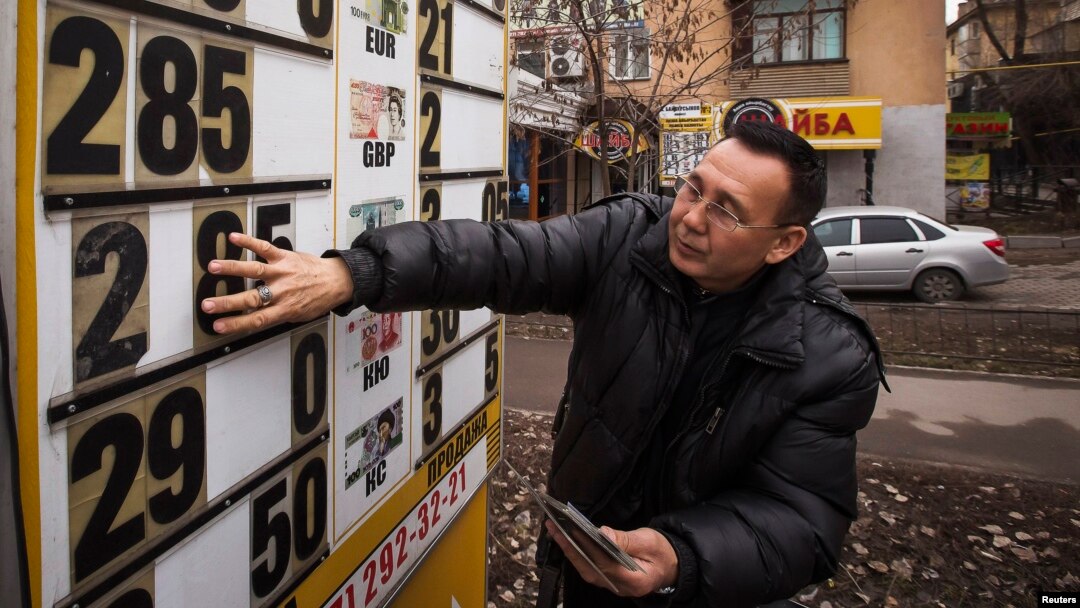 An employee changes an exchange rate sign at a currency exchange office in Almaty in February.