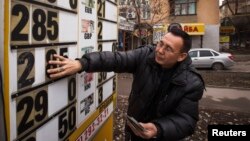 An employee changes an exchange rate sign at a currency exchange office in Almaty in February.