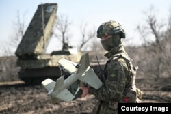 A Russian soldier guards a rocket artillery position with an Elka system.