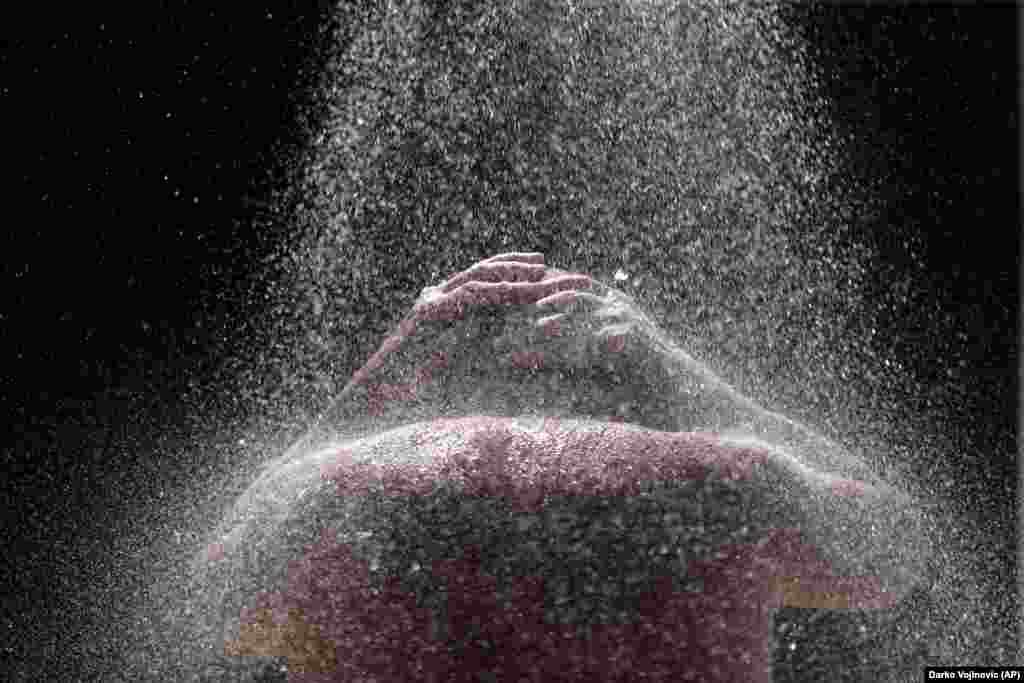 A man takes a cold shower at Ada Ciganlija lake in the Serbian capital, Belgrade. (AP/Darko Vojnovic)